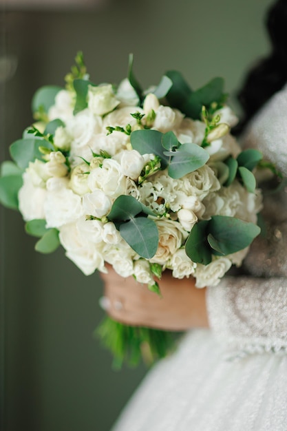 Ragazza con un vestito birdal con un bouquet di rose