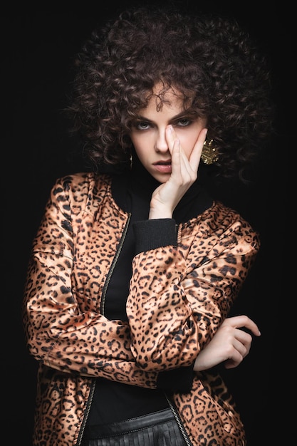 Ragazza con una giacca leopardata su uno sfondo nero