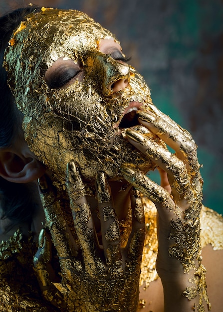 Ragazza con una maschera sul viso in foglia d'oro.