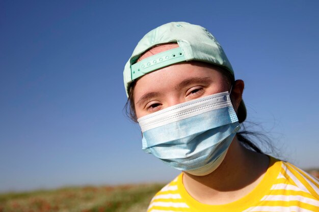 Ragazza con una maschera sul viso sullo sfondo di un cielo blu