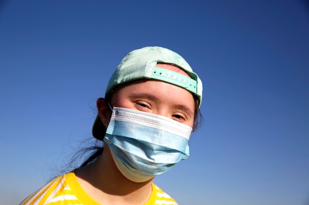 Ragazza con una maschera sul viso sullo sfondo di un cielo blu