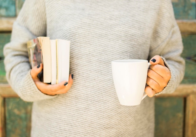 Ragazza con una tazza di caffè e libri