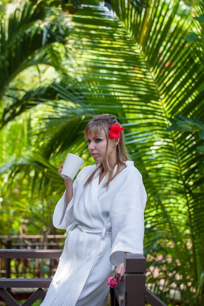 Ragazza con una tazza di caffè mattutino in giardino