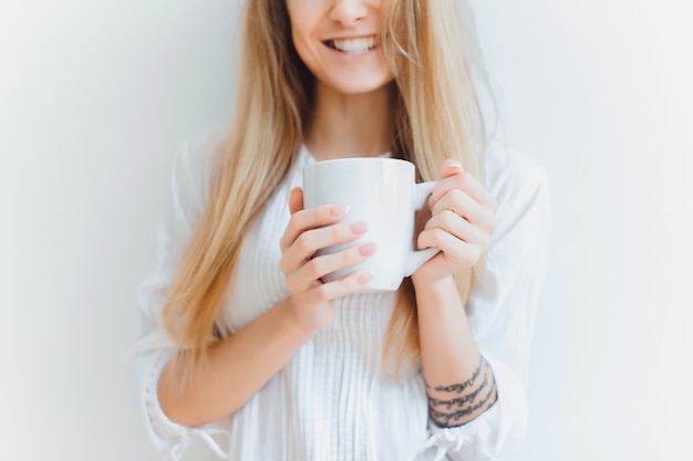 Ragazza con una tazza di caffè su uno sfondo bianco