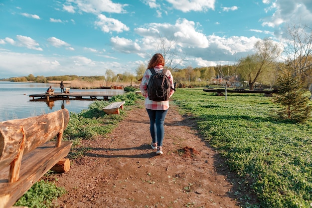 Ragazza con uno zaino viaggia. ragazza felice in natura