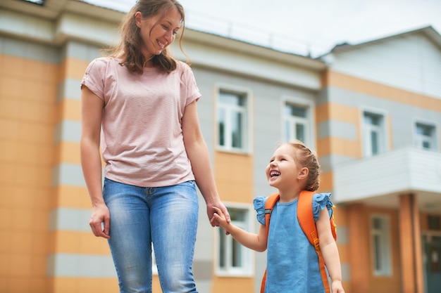 Ragazza con valigette vicino alla scuola.