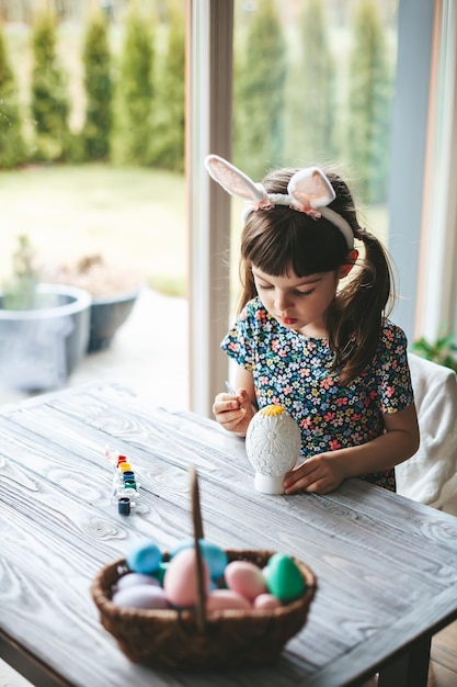 Ragazza concentrata che dipinge l'uovo di Pasqua