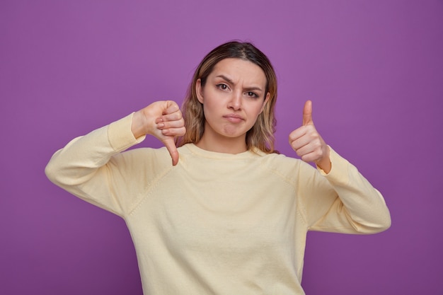 Ragazza confusa che mostra pollice su e giù