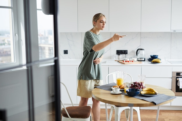 Ragazza contemporanea che fotografa alimento sulla tavola servita