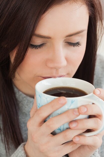 Ragazza contenta che beve una tazza di caffè