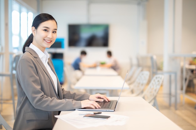 Ragazza d'affari asiatica con successo portatile posa felice Ecommerce University education