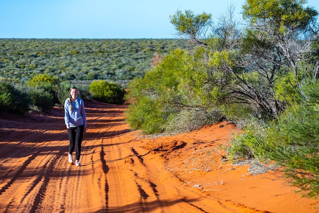 ragazza dai capelli lunghi che fa un'escursione nel deserto di sabbia rossa australiano terra rosa nel parco nazionale di francois peron