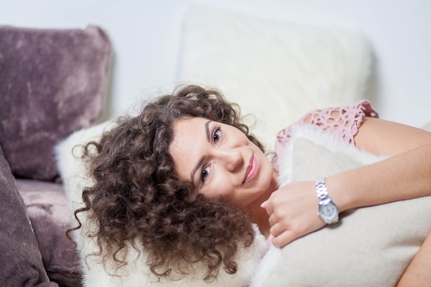 ragazza dai capelli ricci che abbraccia un cuscino prima di andare a letto Giornata mondiale del sonno