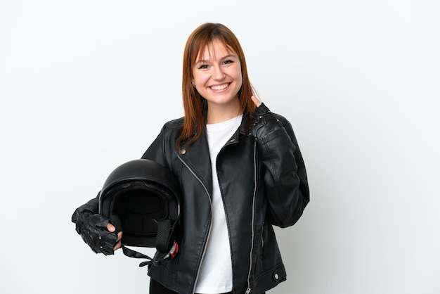 Ragazza dai capelli rossi con un casco da motociclista isolato su sfondo bianco che fa un gesto di pollice in alto