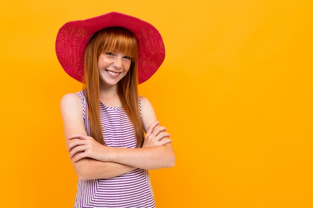 Ragazza dai capelli rossi europea in un cappello rosso estivo