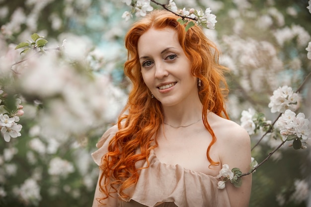 Ragazza dai capelli rossi in un giardino fiorito