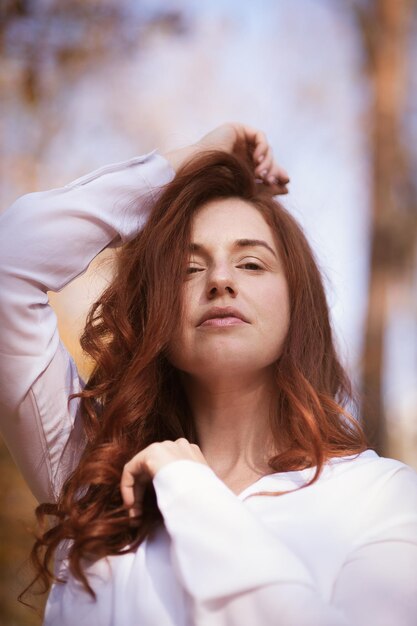 Ragazza dai capelli rossi nel ritratto del fogliame di autunno