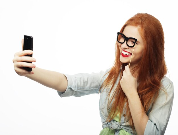 ragazza dai capelli rossi pronta per la festa, scatta un selfie