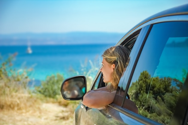 ragazza dalla macchina in mare in Grecia