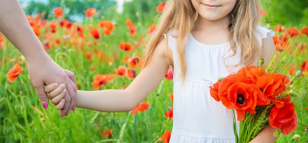 Ragazza dei bambini in un campo con i papaveri.