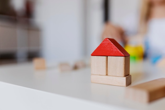 Ragazza del bambino che gioca con blocchi di costruzione giocattolo in legno colorato. Ragazzino che costruisce una torre o una casa a casa o all'asilo. Giocattoli educativi per bambini piccoli. Blocco da costruzione per neonati o bambini piccoli