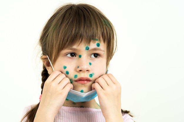 Ragazza del bambino che indossa maschera medica protettiva blu