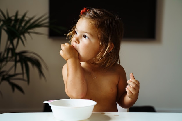 Ragazza del bambino che mangia biscotto e beve il succo. Spuntino per bambino. Filmati 4K di alta qualità