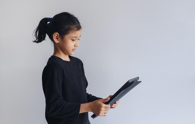 Ragazza del bambino che osserva lo studio digitale della compressa in linea. bambina in chat apprendimento online.