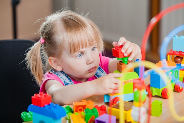 Ragazza del bambino con i giocattoli variopinti