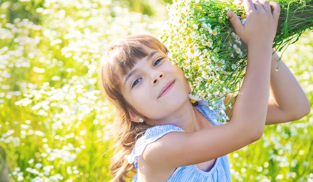 Ragazza del bambino in un campo di camomilla