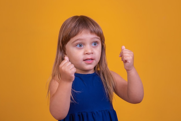 Ragazza del bambino piccolo con il pollice in su. Bambina che dà il pollice in su con la mano