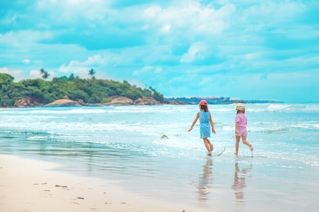 Ragazza del bambino sulla spiaggia nell'oceano. Messa a fuoco selettiva.