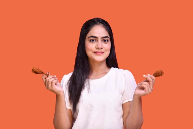 ragazza del cibo che indossa una maglietta sorridente e tiene in mano una bacchetta modello indiano pakistano