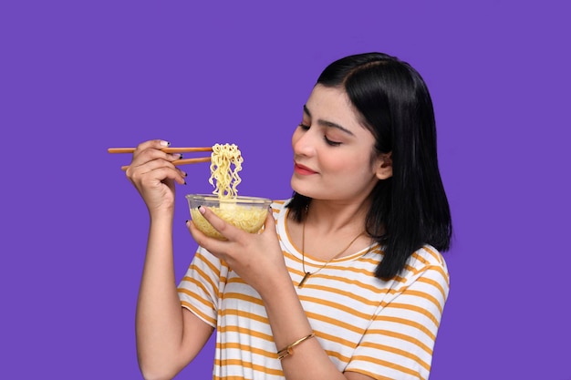 ragazza del cibo che sorride e tiene in mano una ciotola di noodles modello pakistano indiano