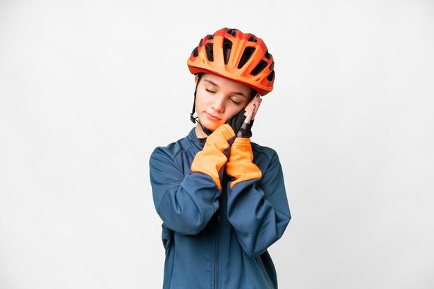 Ragazza del ciclista dell'adolescente sopra fondo bianco isolato che fa gesto di sonno nell'espressione dorable