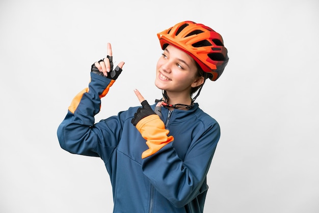 Ragazza del ciclista dell'adolescente sopra fondo bianco isolato che indica con il dito indice una grande idea