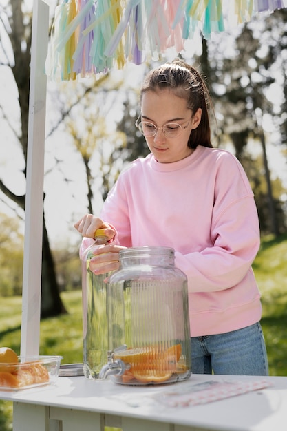 Ragazza del colpo medio che fa limonata