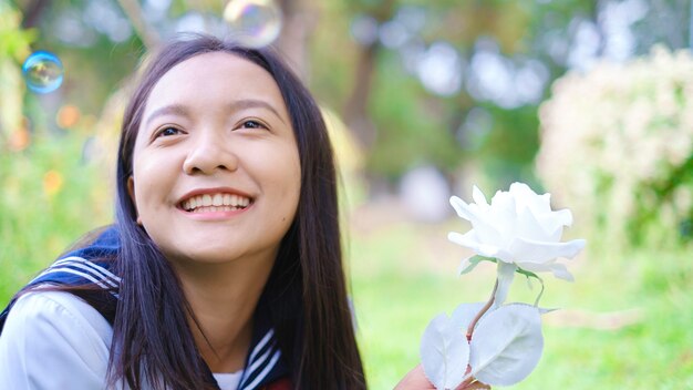 Ragazza del ritratto dell'allievo nella scuola dell'uniforme sopra al giardino Ragazza asiatica Adolescente