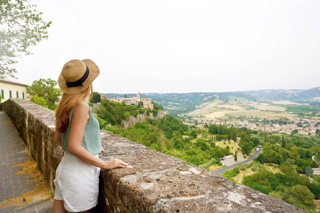 Ragazza del viaggiatore che gode della vista delle colline dell'Umbria dalla città di Orvieto in Italia