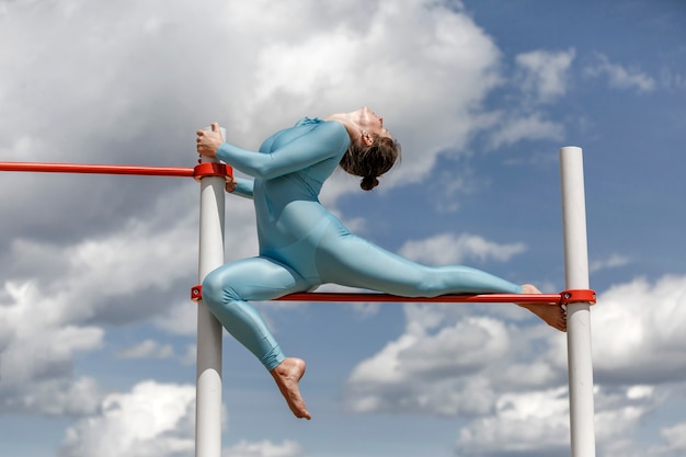 Ragazza dell'acrobata in un vestito blu sulla strada