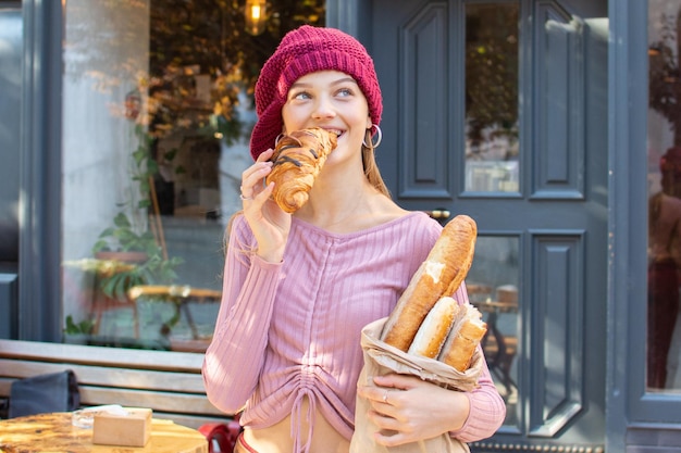 Ragazza dell'adolescente che mangia un croissant fresco