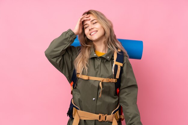 Ragazza dell'alpinista dell'adolescente con un grande zaino sul sorridere rosa molto