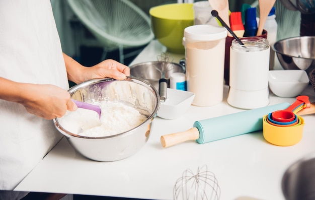 Ragazza della donna in cucina che cucina la pasta della polvere del panettiere del panettiere