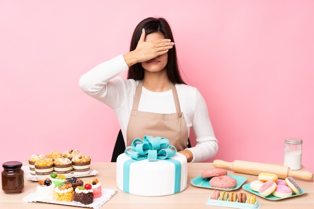 Ragazza della pasticceria sopra la parete isolata