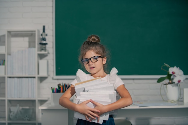 Ragazza della scuola che studia matematica sulla lezione in aula alla scuola elementare ragazza della scuola del secchione in vetri wi