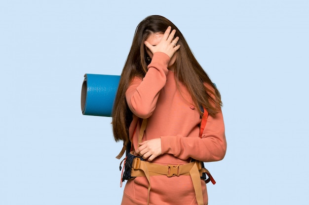 Ragazza della viandante con l'espressione stanca sopra sul blu