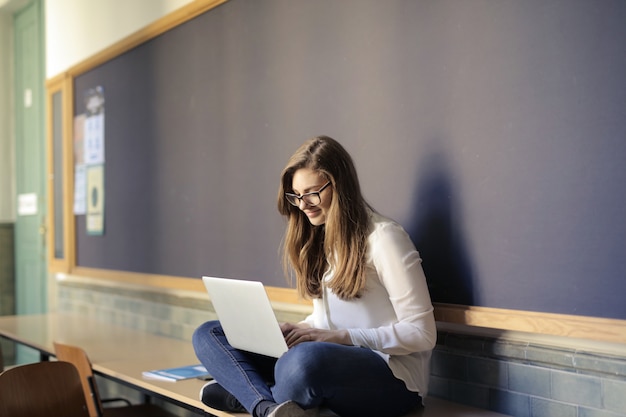 Ragazza dello studente che lavora su un computer portatile