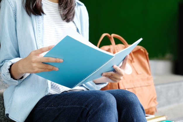 Ragazza dello studente che si siede e che legge libro, istruzione, di nuovo al concetto della scuola