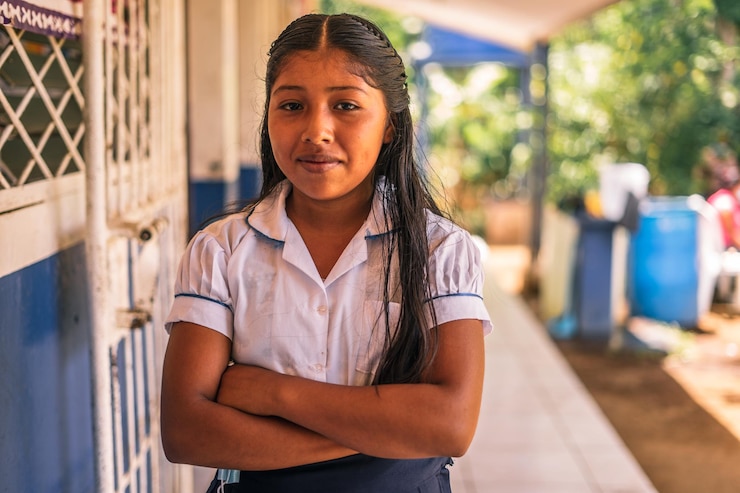 Ragazza dello studente elementare nicaraguense che sorride e che esamina la macchina fotografica