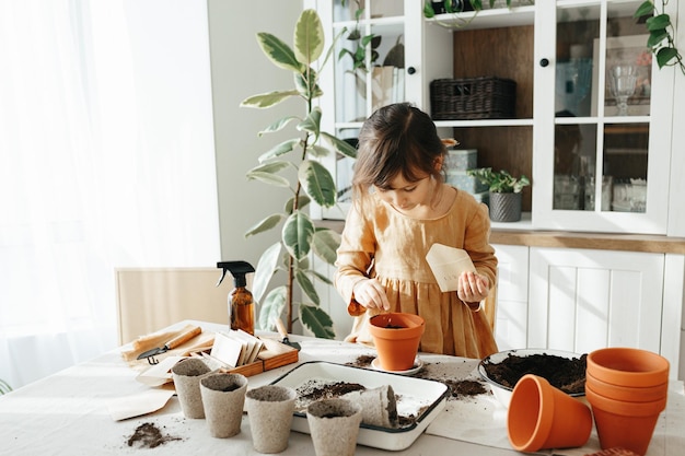 Ragazza di 6 anni che pianta erbe a casa